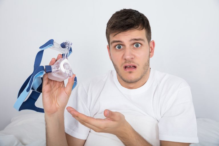 Young Man Holding CPAP mask