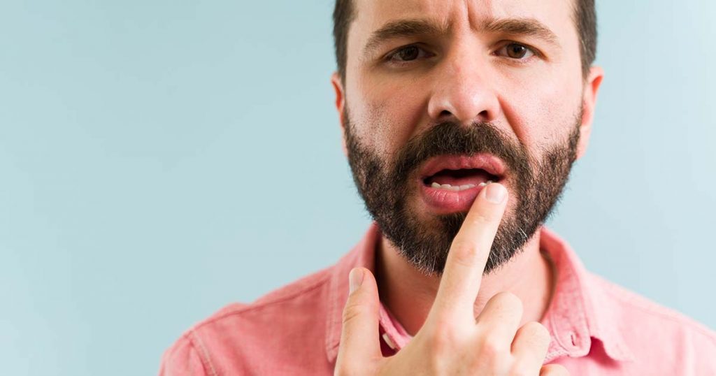 man pointing to dry mouth