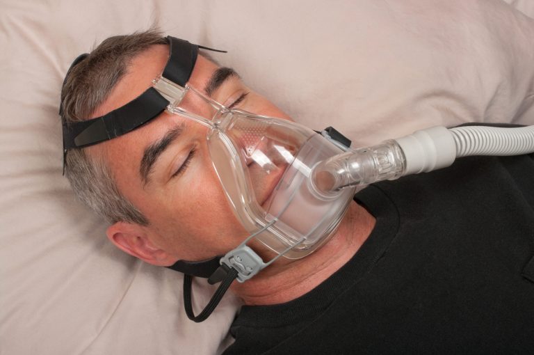 man sleeping with full face CPAP mask