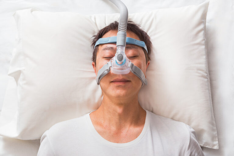 man sleeps with nasal CPAP mask