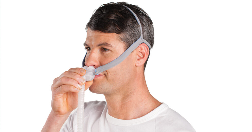 Photo of a person wearing a Nasal Pillow CPAP Mask