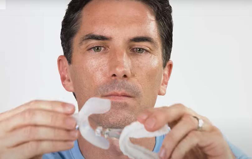 Man showing how to use the MyTAP oral appliance for sleep apnea