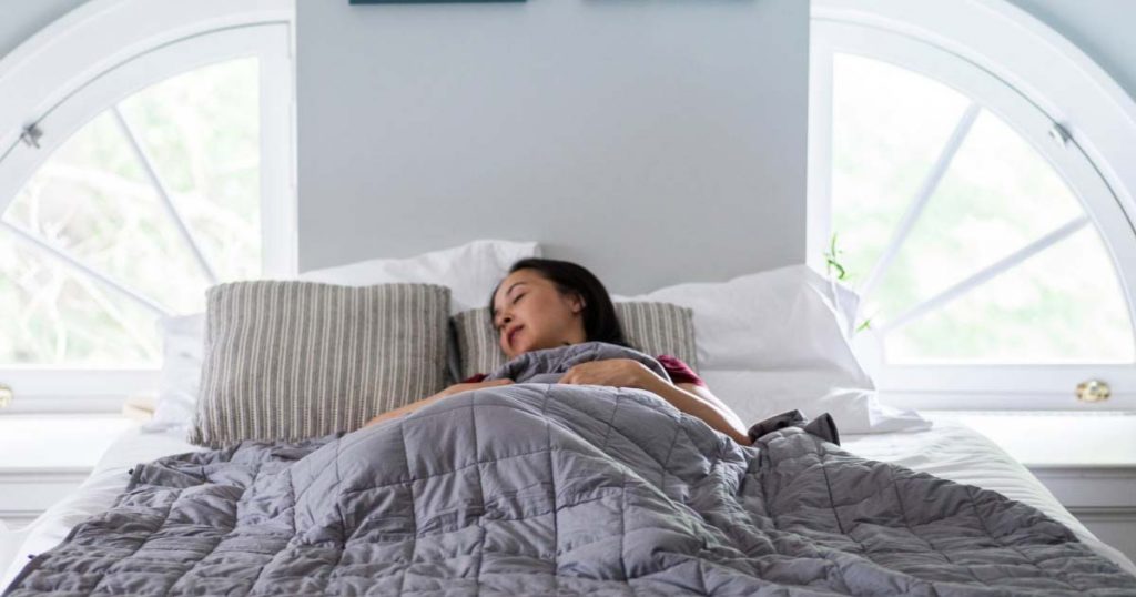 Woman sleeping with a weighted blanket for comfort