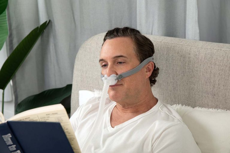 Man wearing the AirFit p10 cpap mask while reading