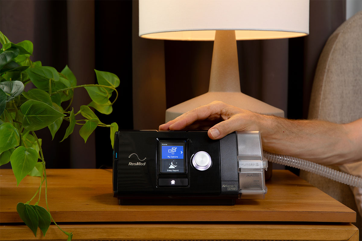 ResMed AirSense 10 next to bed on nightstand.
