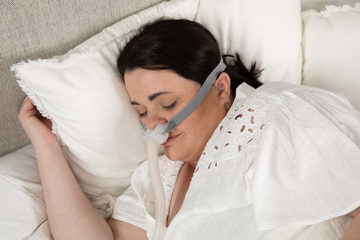 Woman wearing the Airfit p10 cpap mask for her in bed.