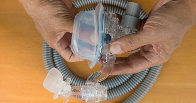man cleaning his cpap mask and tubing to prevent mold