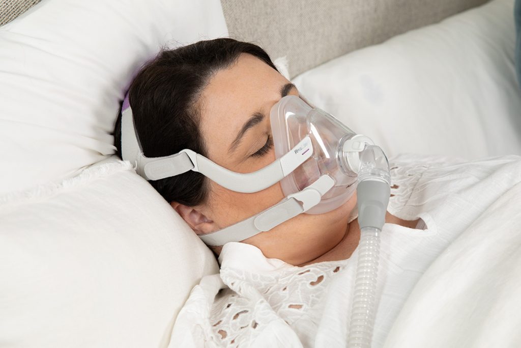 Woman sleeping soundly wearing AirFit F20 CPAP Mask