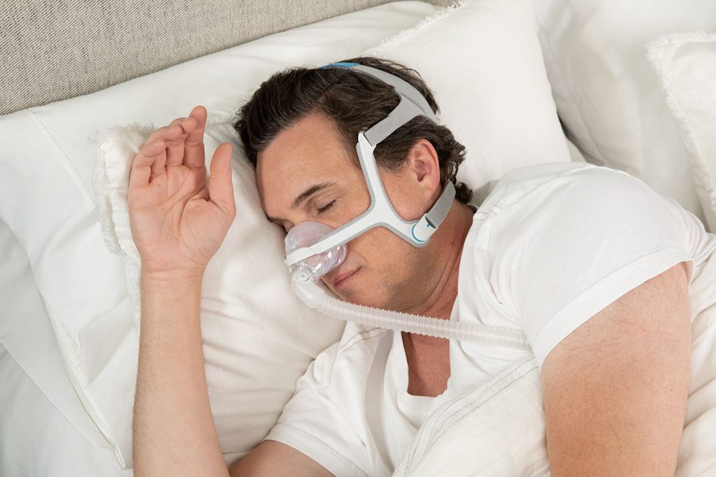 man sleeps soundly wearing AirFit n20 cpap mask