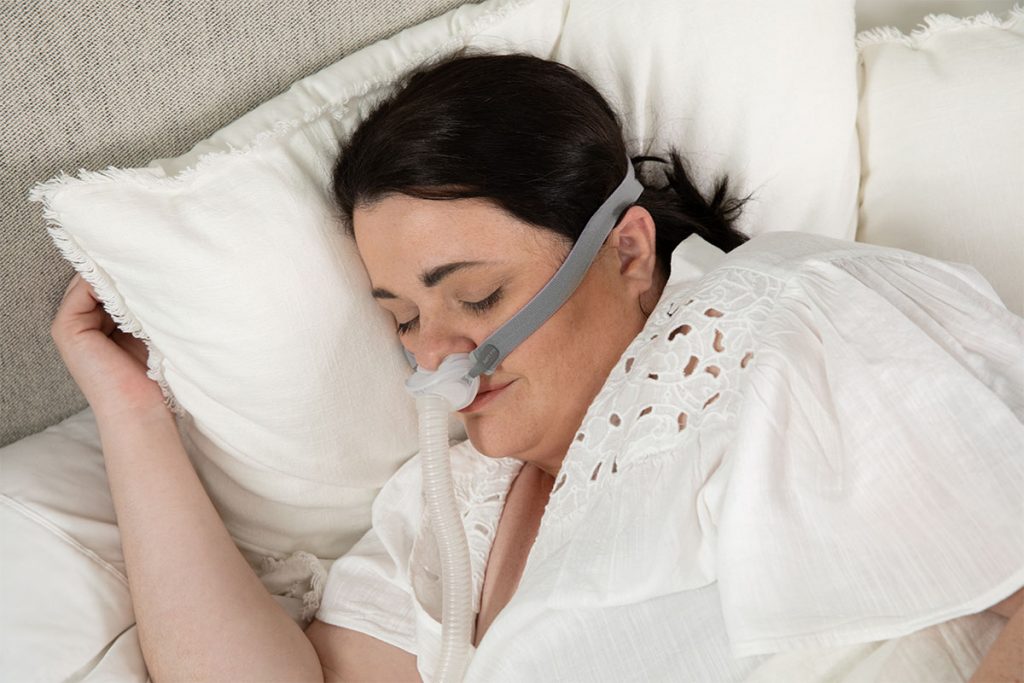 Woman sleeping soundly while wearing AirFit P10 nasal pillow mask