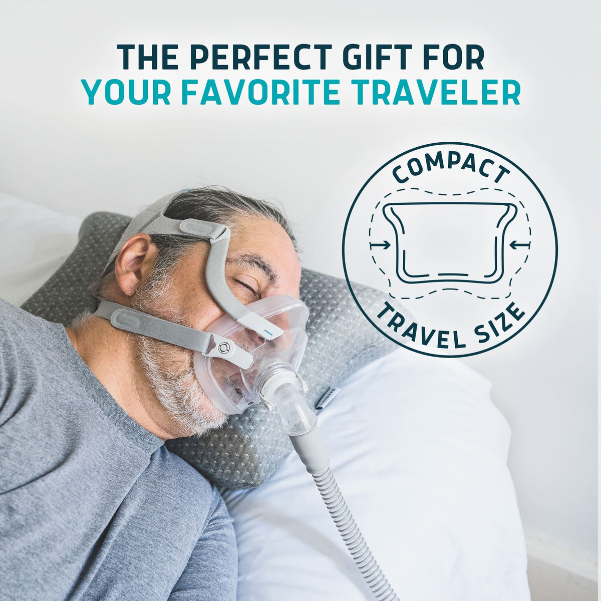 Man wearing a CPAP mask sleeping on a grey Lunderg travel-size memory foam pillow.