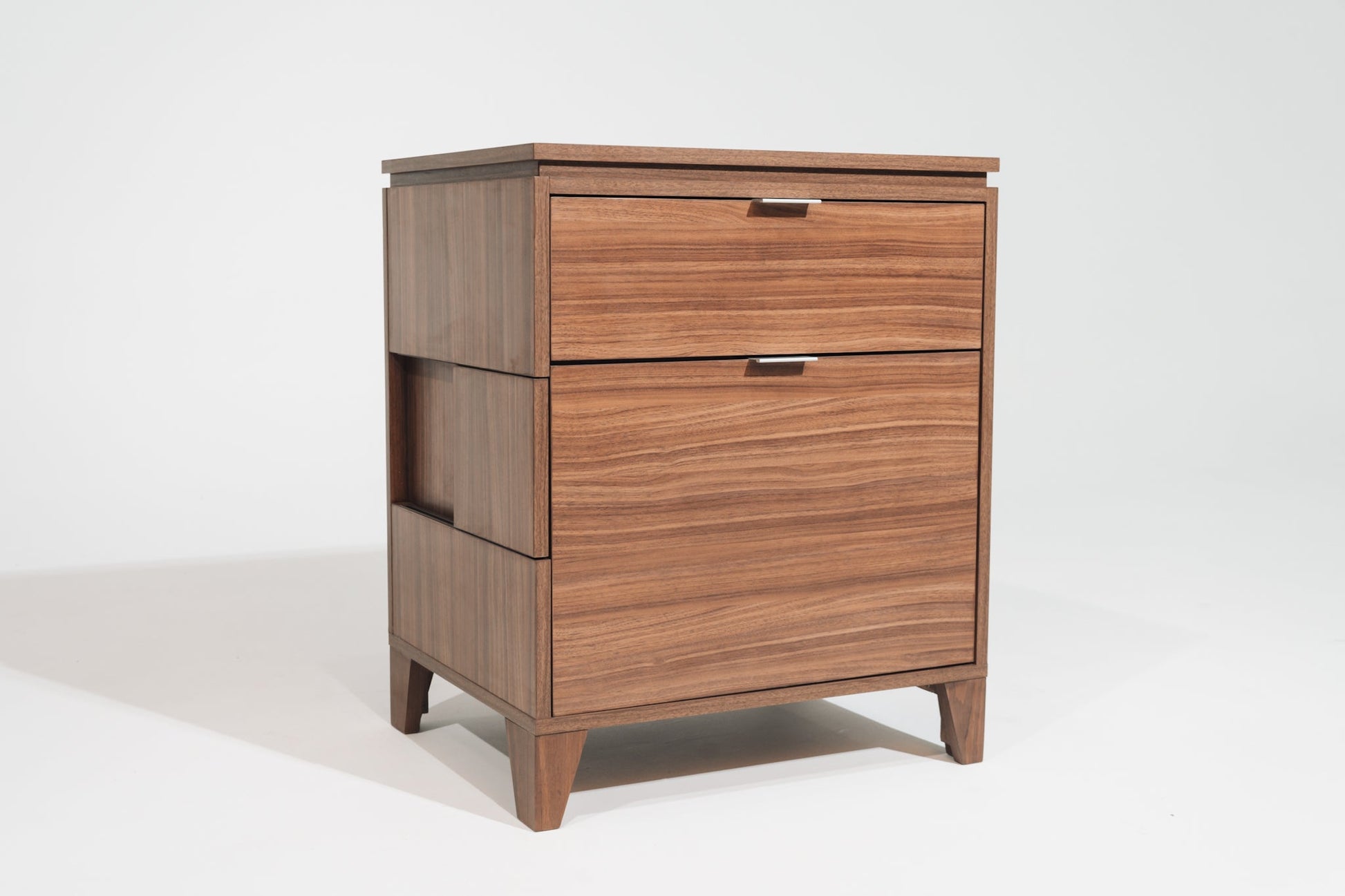 A CPAP nightstand in Soho Walnut finish, featuring a modern design with two drawers, sleek metal handles, and subtle wood grain patterns. The nightstand has side cutouts for easy access and stands on tapered legs for a contemporary aesthetic.
