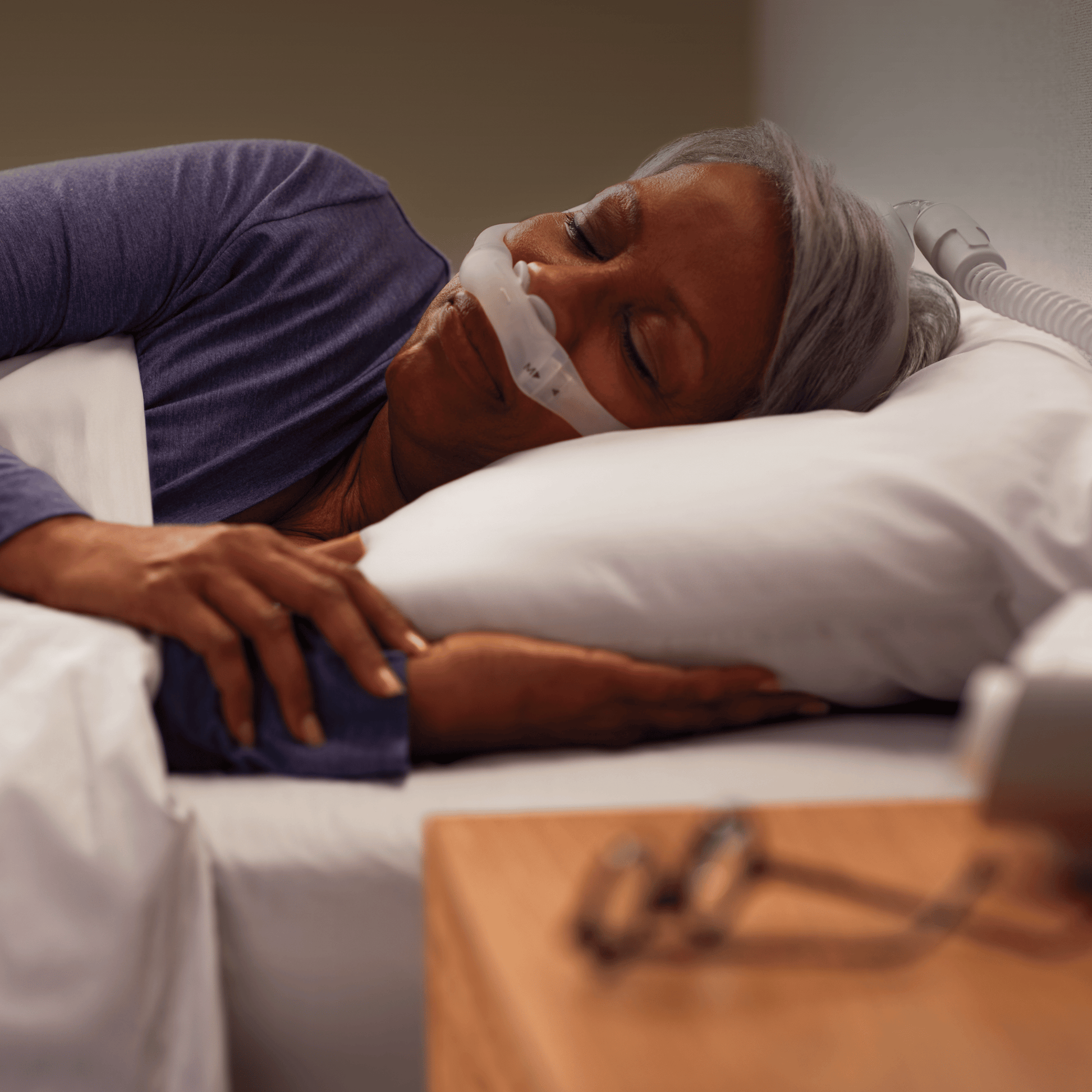 a woman sleeps soundly while wearing the dreamwear nasal pillow cpap mask
