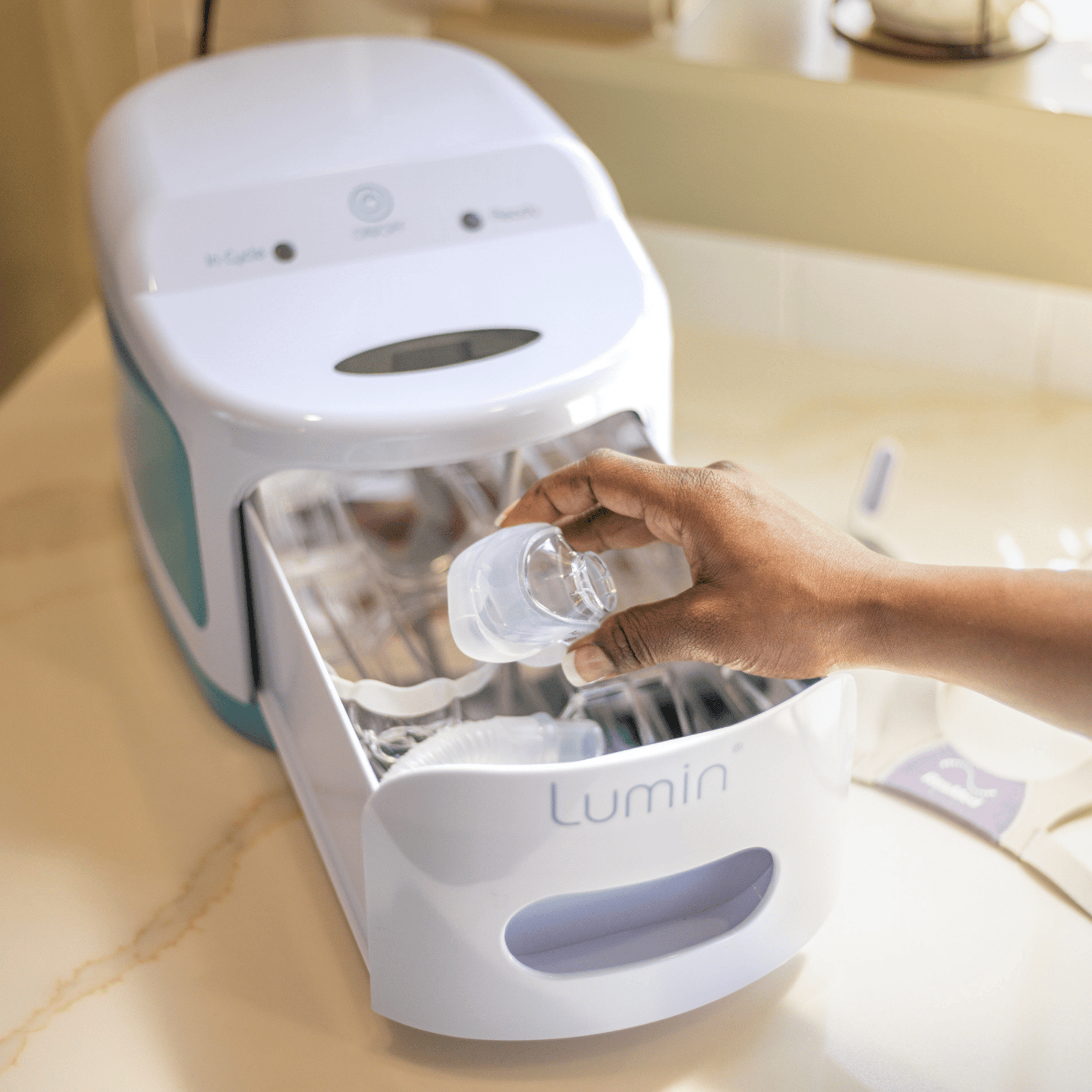 a hand places an airfit n20 cushion into the lumin's sanitizing chamber