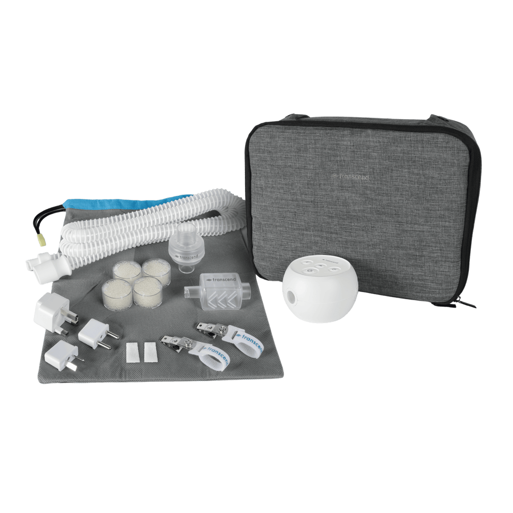 Bundle shot of the Transcend Micro 510 Essentials Bundle, featuring the SleepPak Travel Bag, a smaller mesh travel pouch, extra tubing, replacement airmist hme cartridges and housing, a replacement muffler, replacement woven filters, international plug adapters, and two hose management clips. 