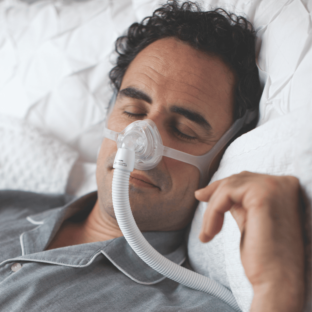 man sleeping soundly wearing wisp nasal mask with silicone frame