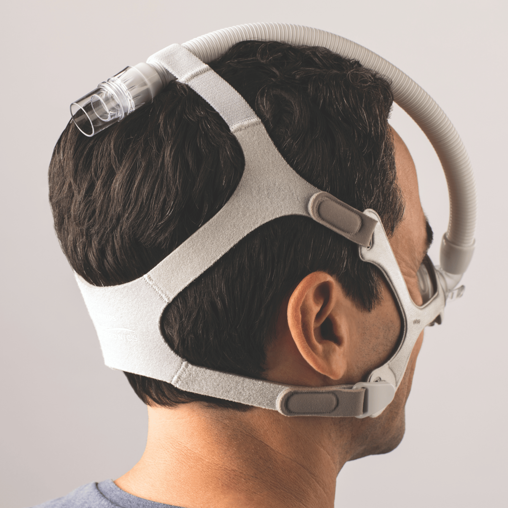 wisp nasal mask shown from the back in the tube up configuration which routes the short tube over the head through a loop in the headgear